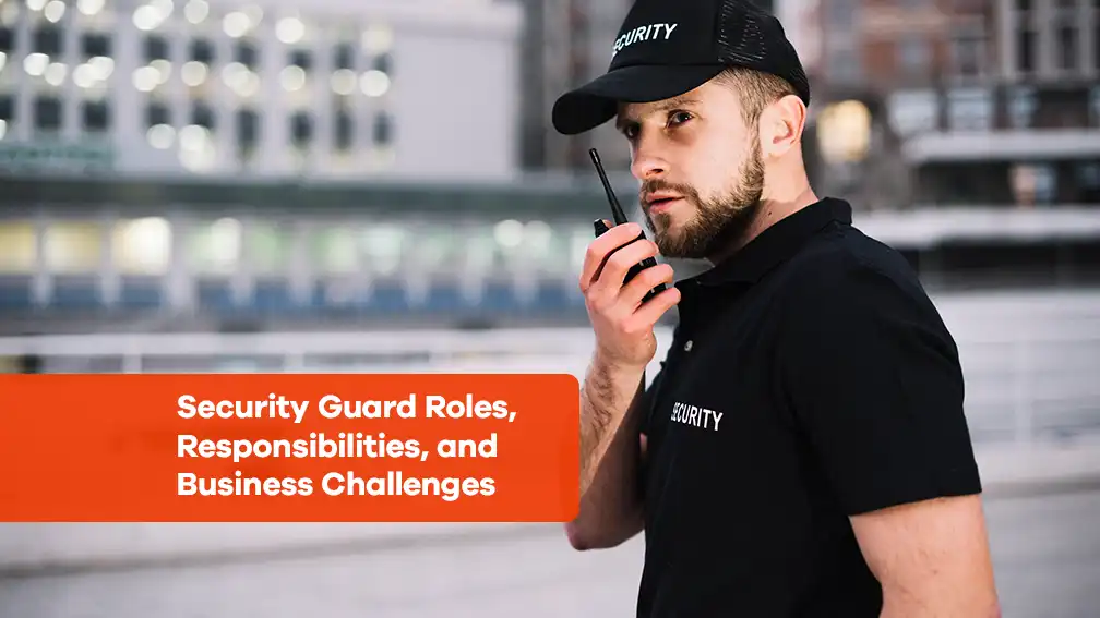 A security guard in uniform, holding a walkie-talkie, stands alert outdoors. The image is overlaid with the text "Security Guard Roles, Responsibilities, and Business Challenges.