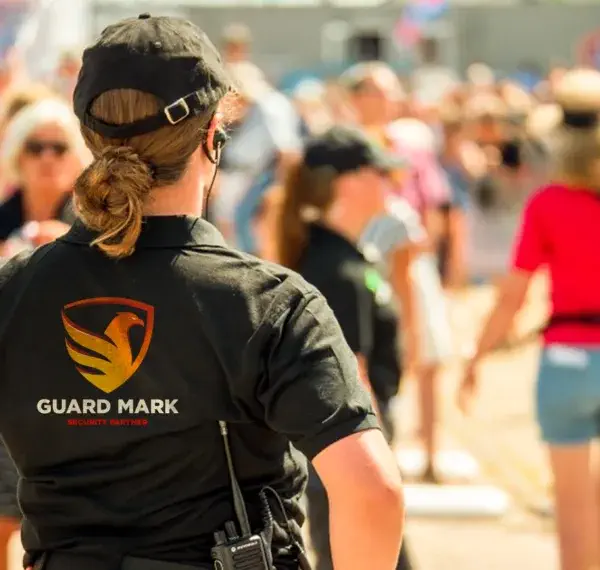 Event security guard in guard mark uniform ensures safety at sporting and music festivals.